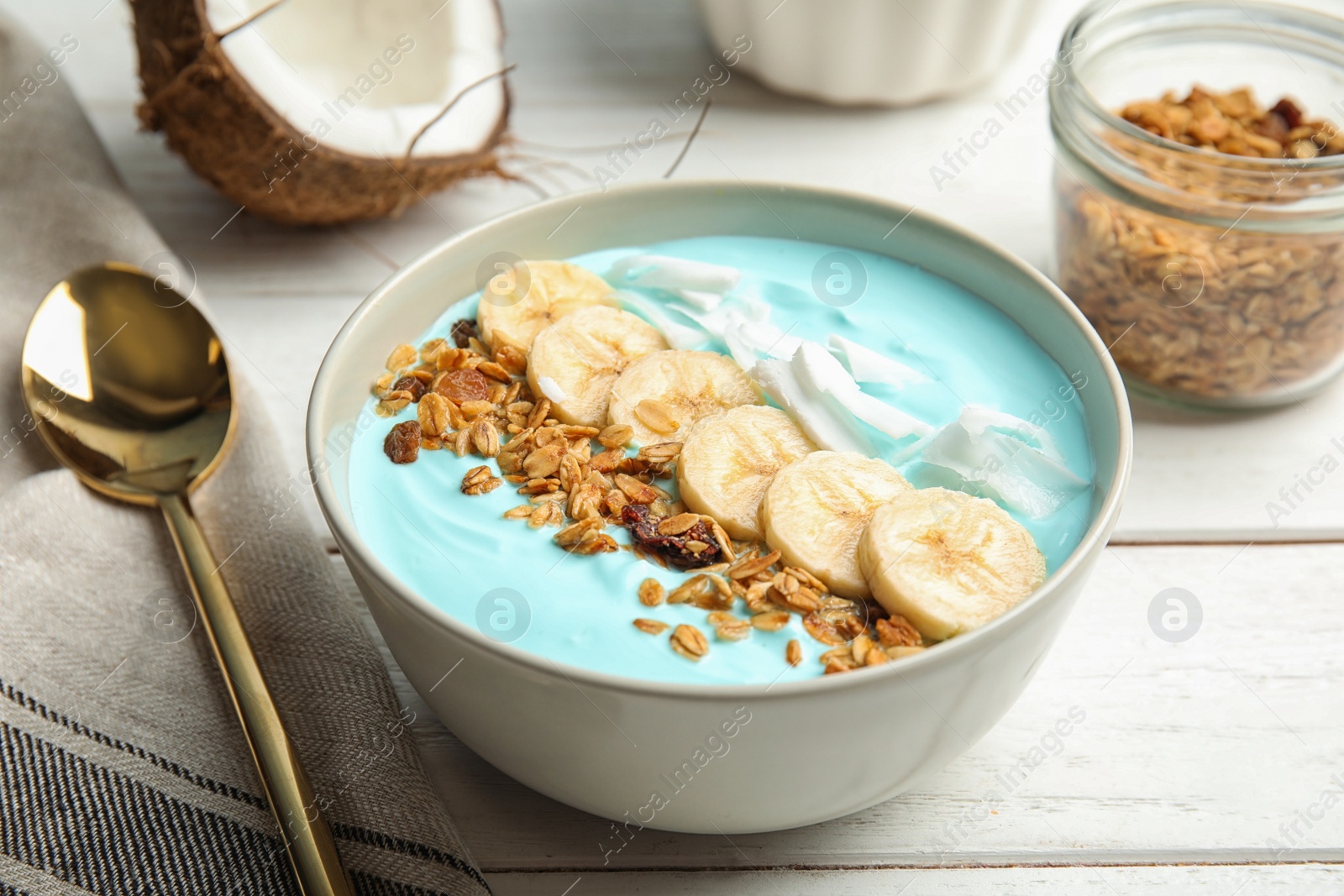 Photo of Bowl of spirulina smoothie and spoon on wooden table