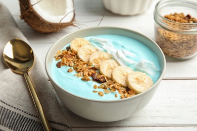 Bowl of spirulina smoothie and spoon on wooden table