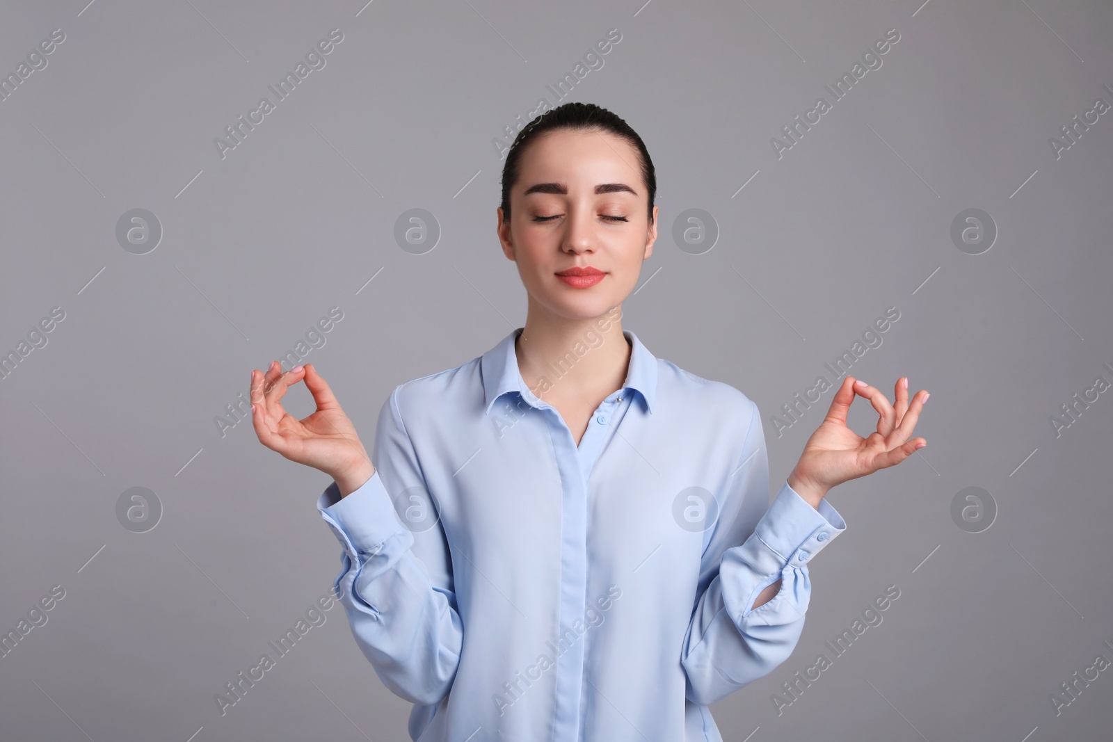 Photo of Young woman meditating on light grey background. Personality concept