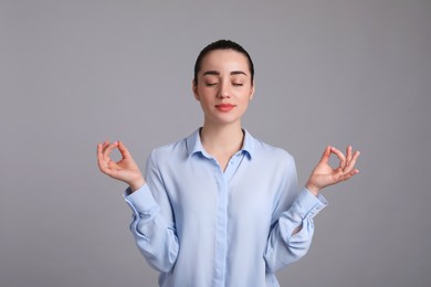 Photo of Young woman meditating on light grey background. Personality concept