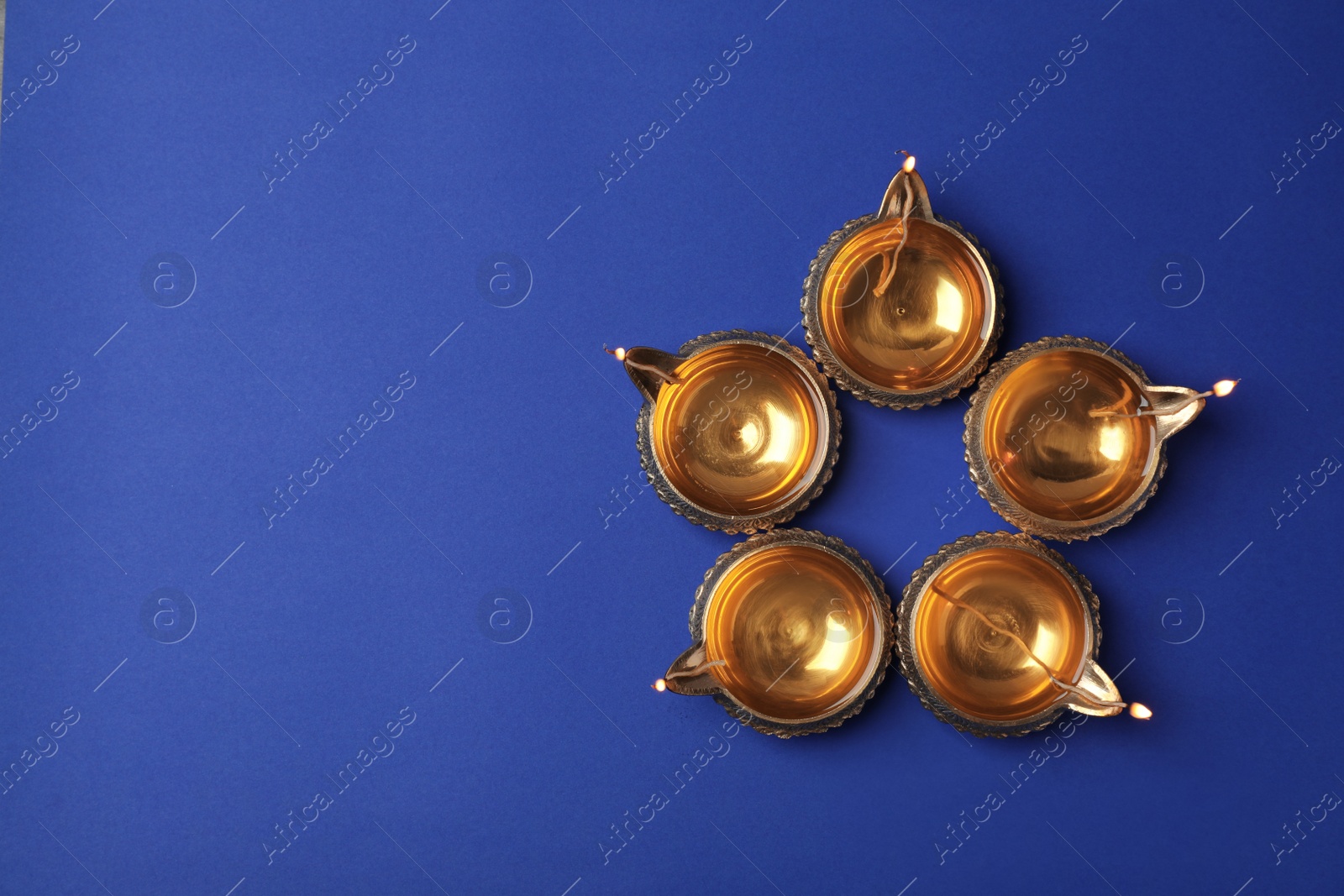 Photo of Diwali diyas or clay lamps on color background, top view