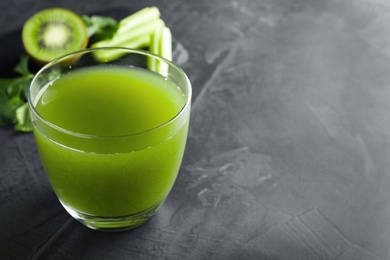 Photo of Glass of fresh celery juice on black table, closeup. Space for text