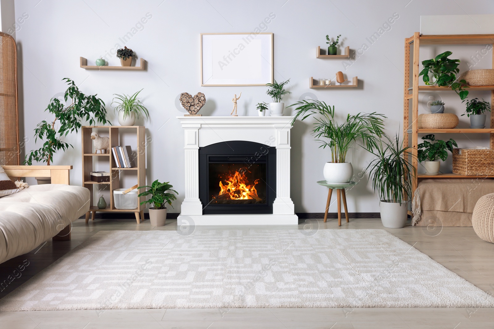 Photo of Stylish living room interior with fireplace, houseplants and beige sofa