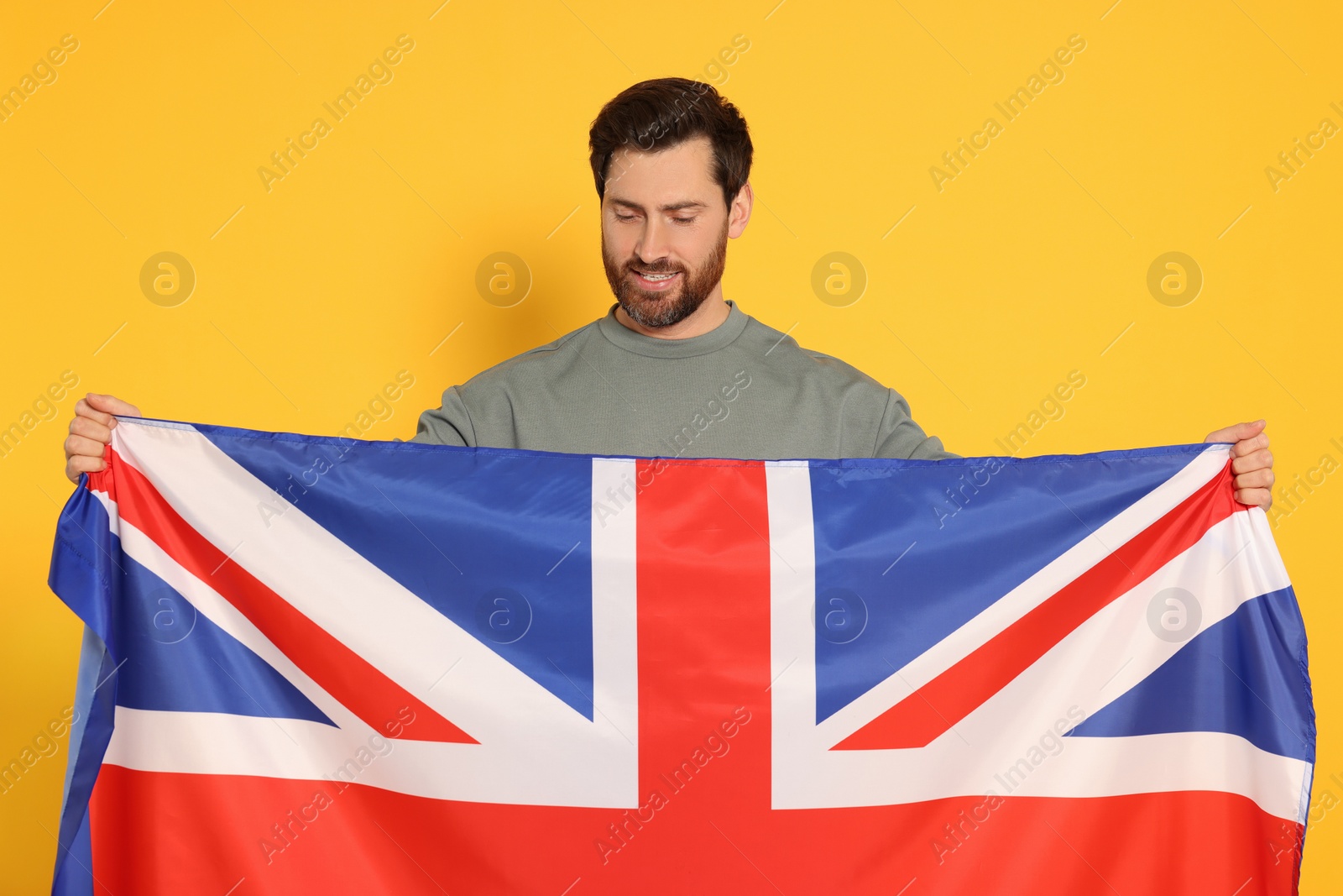 Photo of Man with flag of United Kingdom on yellow background