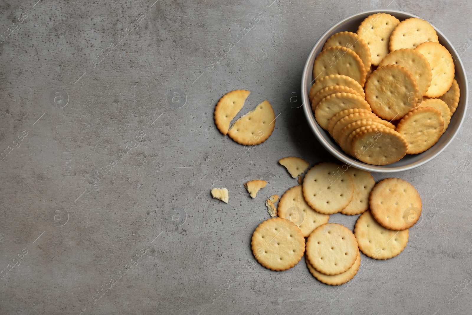 Photo of Delicious crispy crackers on grey table, flat lay. Space for text