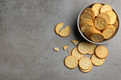 Photo of Delicious crispy crackers on grey table, flat lay. Space for text