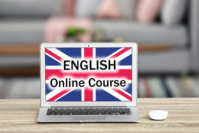 Image of Modern laptop for online English learning on table indoors