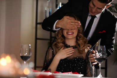 Photo of Man surprising his girlfriend in restaurant at Valentine's day dinner