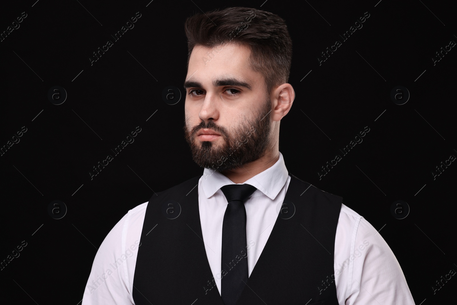 Photo of Handsome businessman in suit and necktie on black background