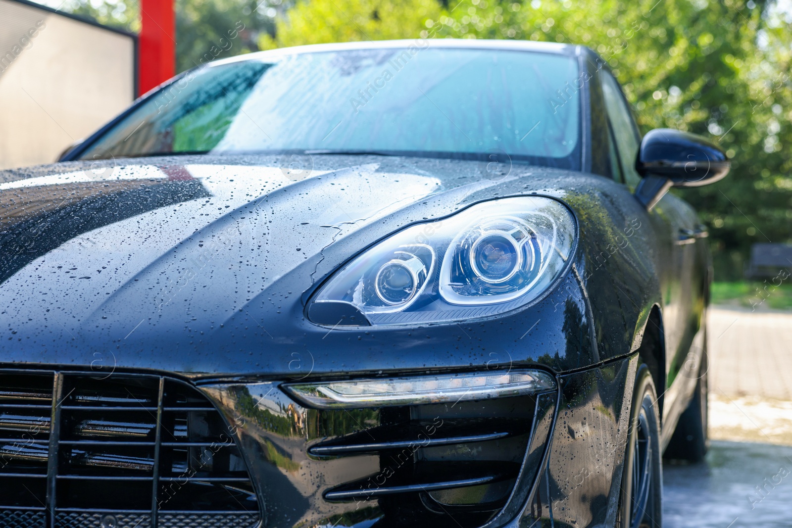 Photo of Clean auto after washing at outdoor car wash, closeup