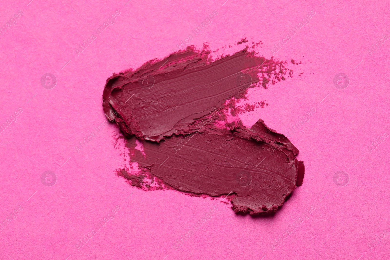 Photo of Smears of beautiful lipstick on pink background, top view