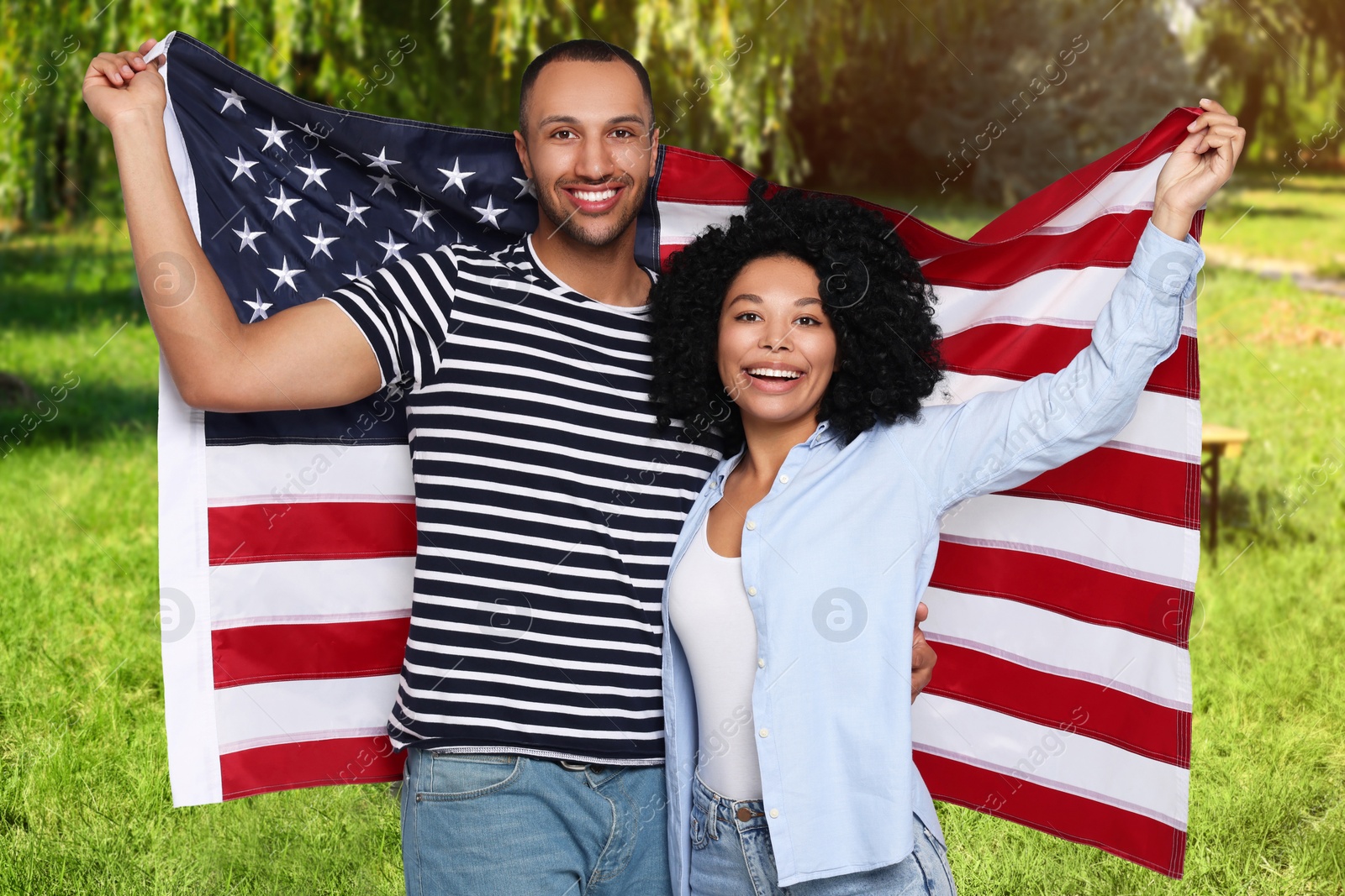 Image of 4th of July - Independence day of America. Happy couple with national flag of United States in park