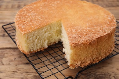 Photo of Tasty sponge cake on wooden table, closeup