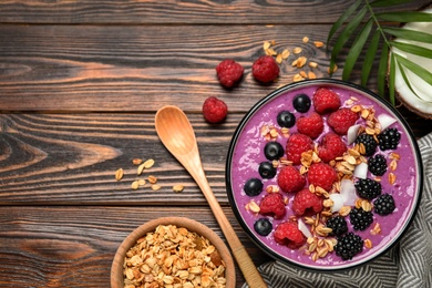 Delicious acai smoothie with fruits served on wooden table, flat lay