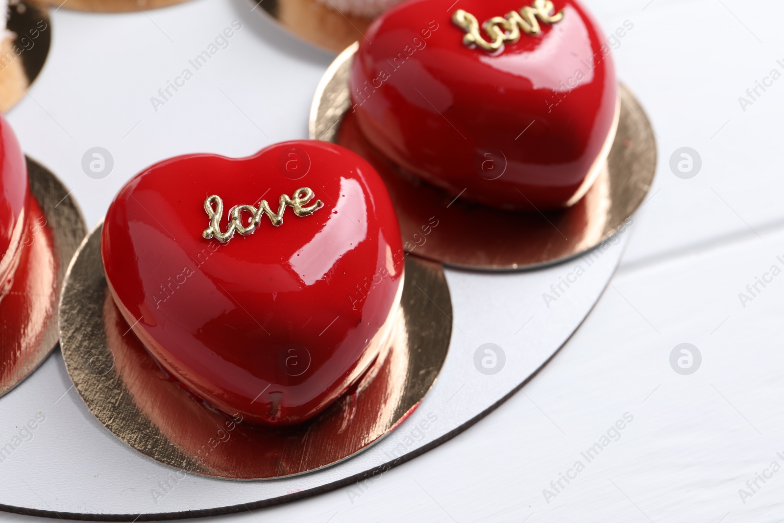 Photo of St. Valentine's Day. Delicious heart shaped cakes on white wooden table, closeup