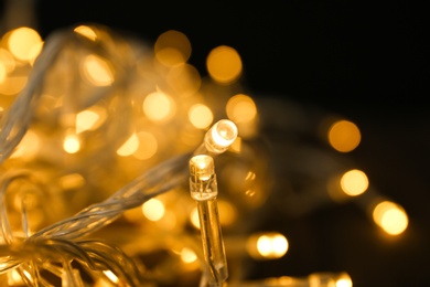 Glowing Christmas lights on table, closeup view