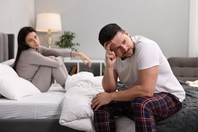Offended husband ignoring his wife in bedroom, selective focus. Relationship problems