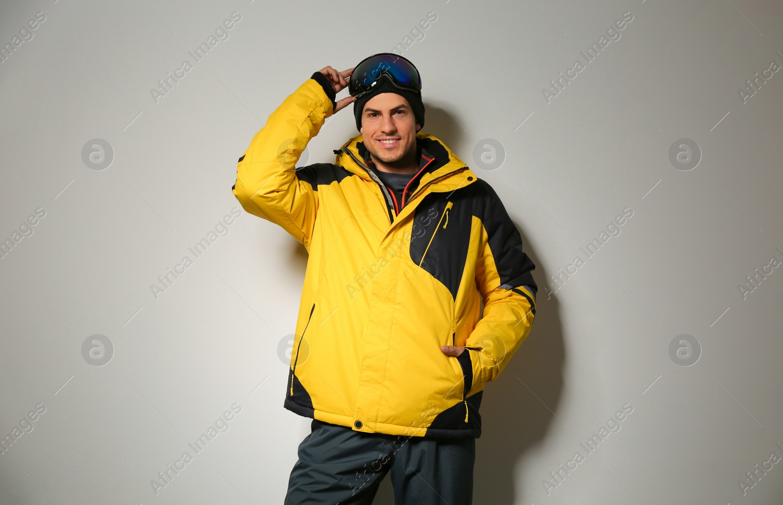 Photo of Man wearing stylish winter sport clothes on light grey background