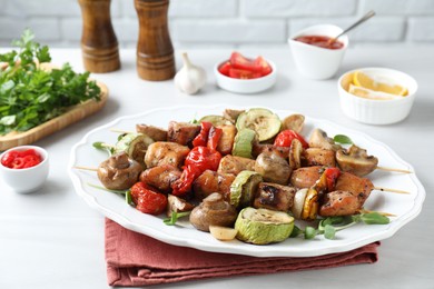 Delicious shish kebabs with vegetables and microgreens served on white table, closeup