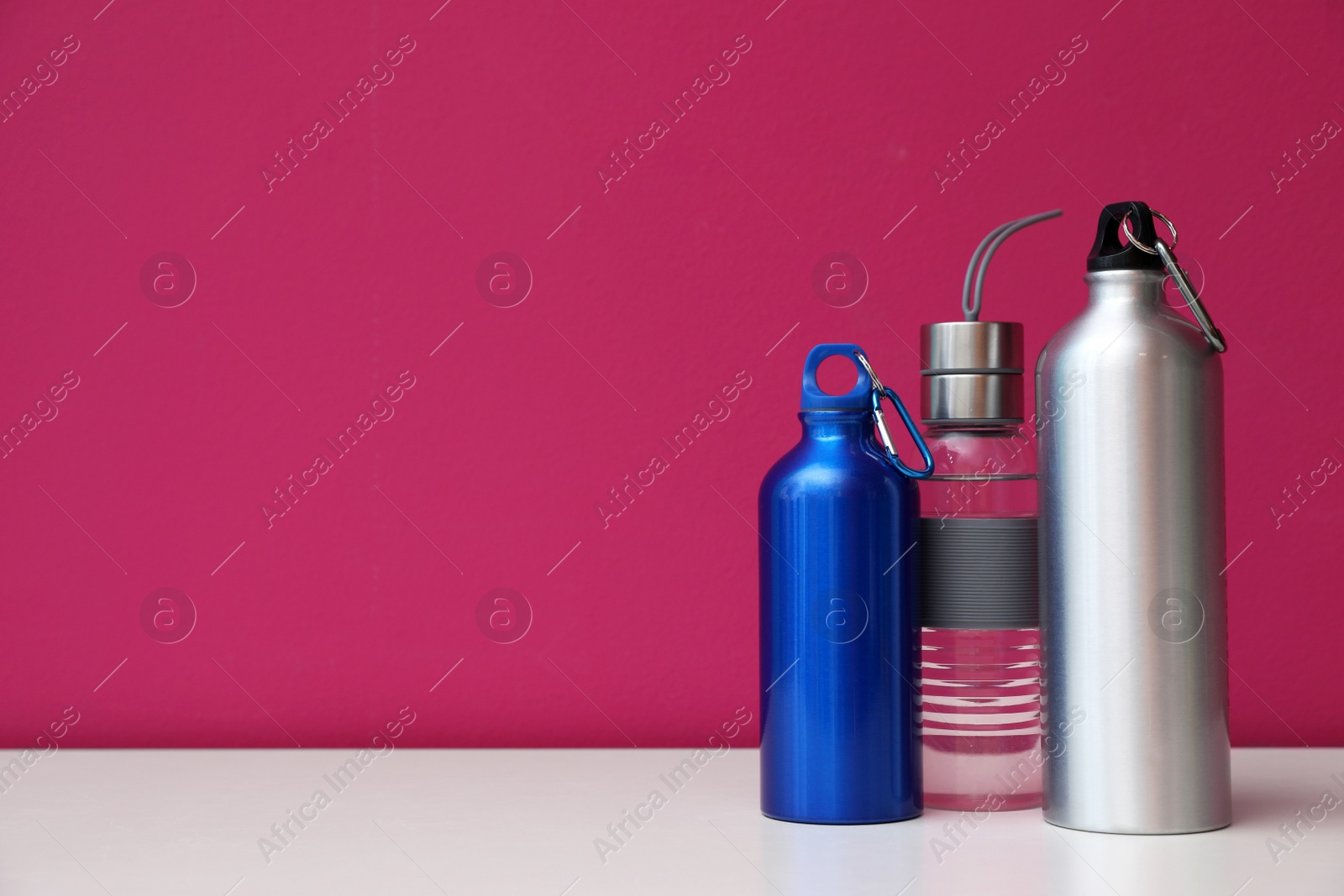 Photo of Different water bottles for sports on color background. Space for text