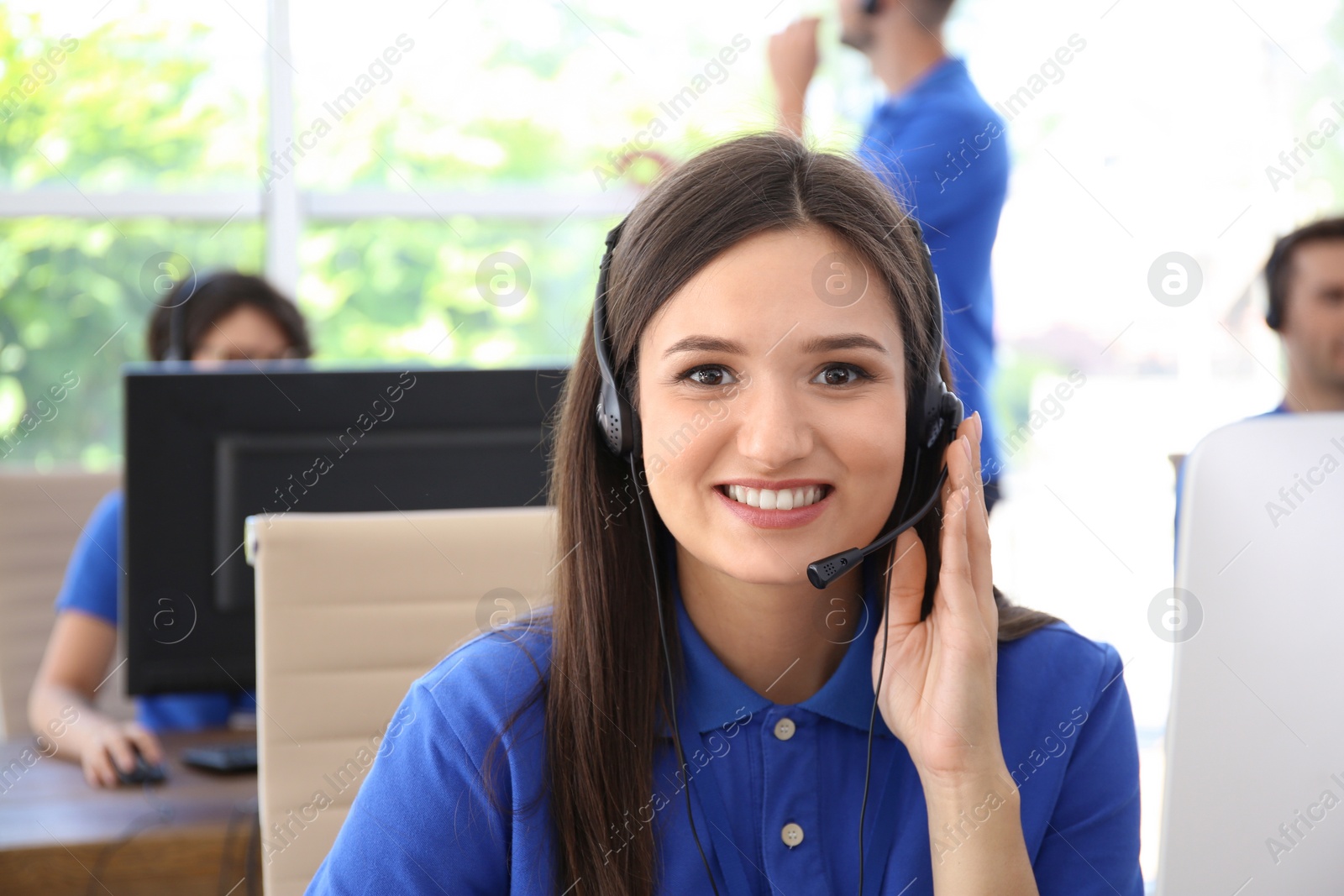 Photo of Female technical support operator with headset at workplace