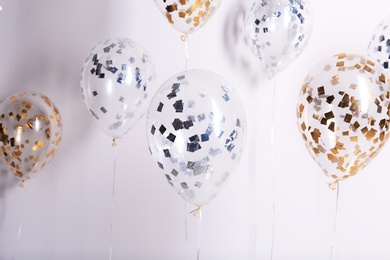 Photo of Bright balloons with sparkles on white background