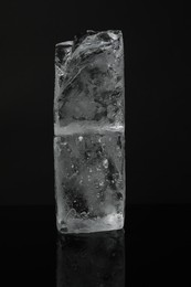 Photo of Blocks of clear ice on black mirror surface