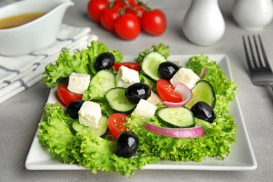 Photo of Tasty fresh Greek salad on grey table