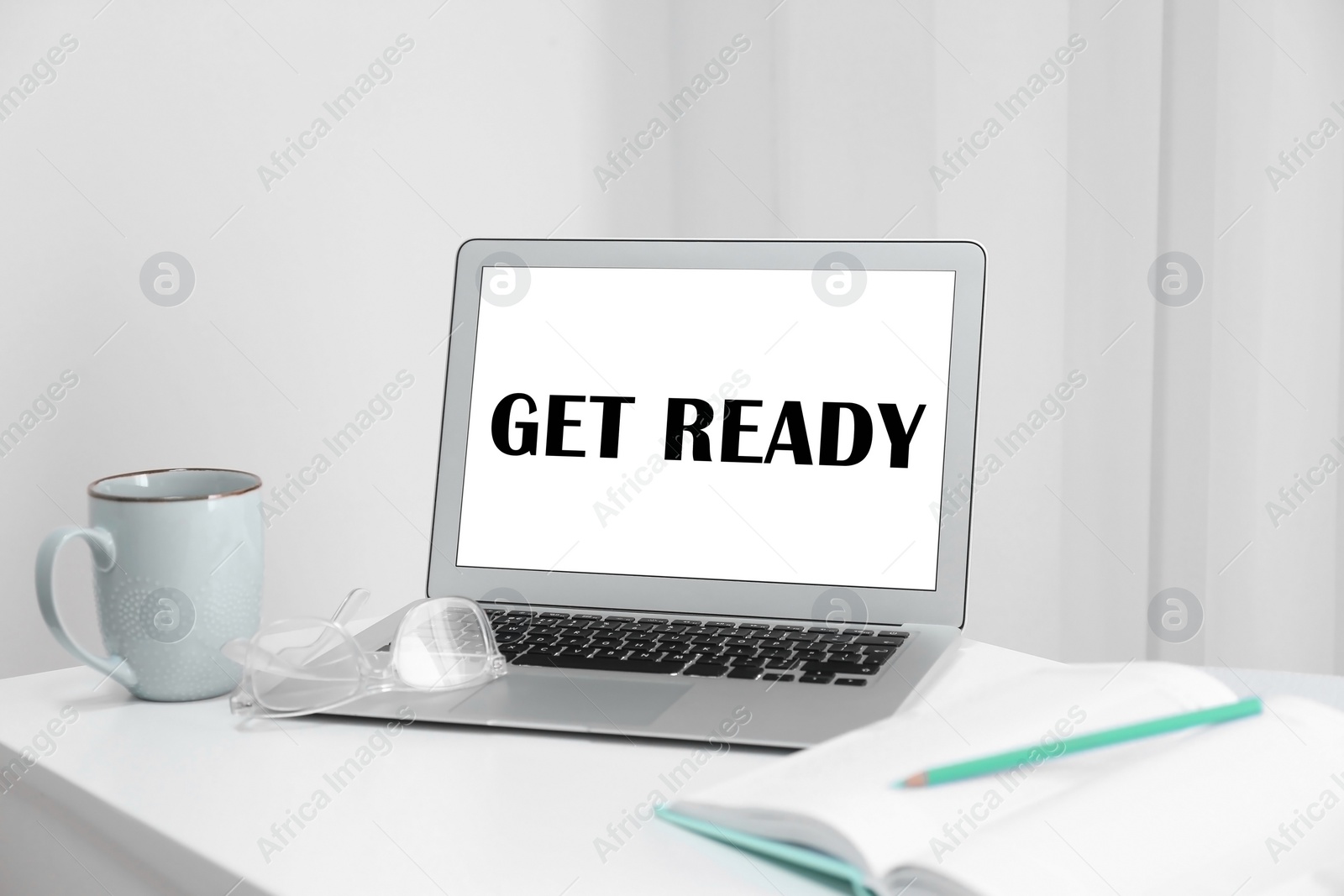 Image of Modern laptop with phrase Get Ready on screen in office