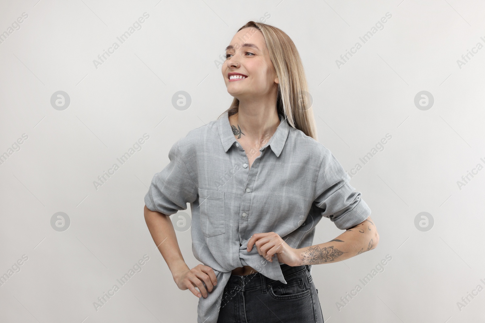 Photo of Portrait of beautiful tattooed woman on light background