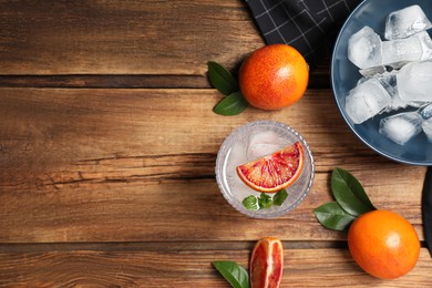 Photo of Delicious refreshing drink with sicilian orange and mint on wooden table., flat lay. Space for text