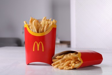 Photo of MYKOLAIV, UKRAINE - AUGUST 12, 2021: Two big portions of McDonald's French fries on white table