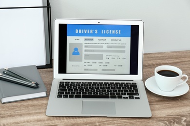 Photo of Laptop with driver's license application form on table in office