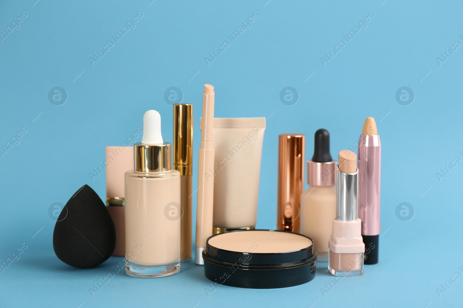 Photo of Foundation makeup products on light blue background. Decorative cosmetics