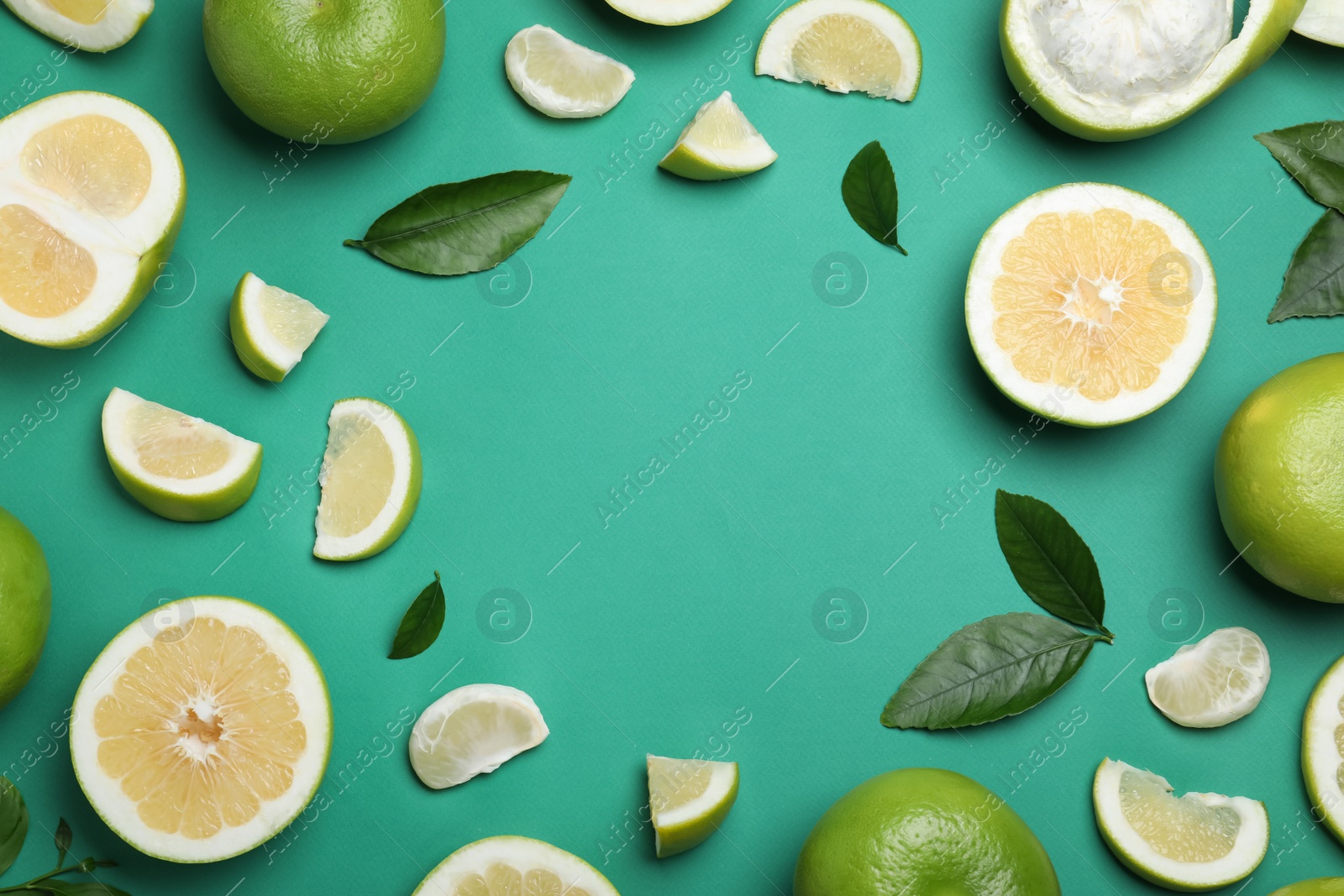 Photo of Frame of fresh ripe sweeties and green leaves on turquoise background, flat lay