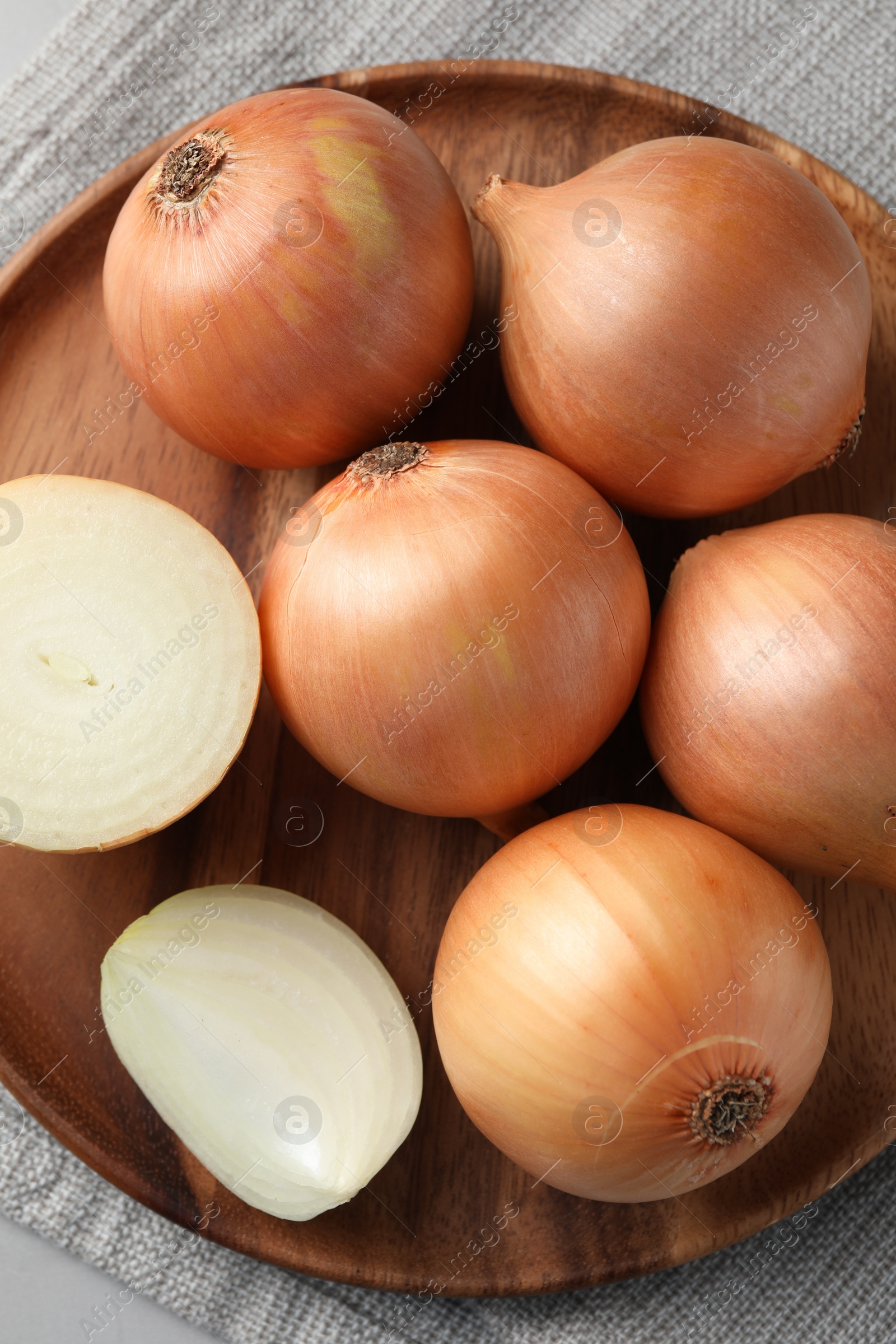 Photo of Whole and cut onions on table, top view