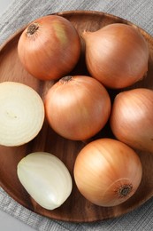 Whole and cut onions on table, top view