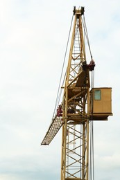 Photo of Construction site with tower crane under cloudy sky