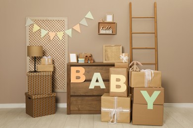 Gift boxes and toys in room decorated for baby shower party