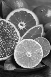 Image of Fresh juicy citrus fruits on plate, closeup. Black and white tone 