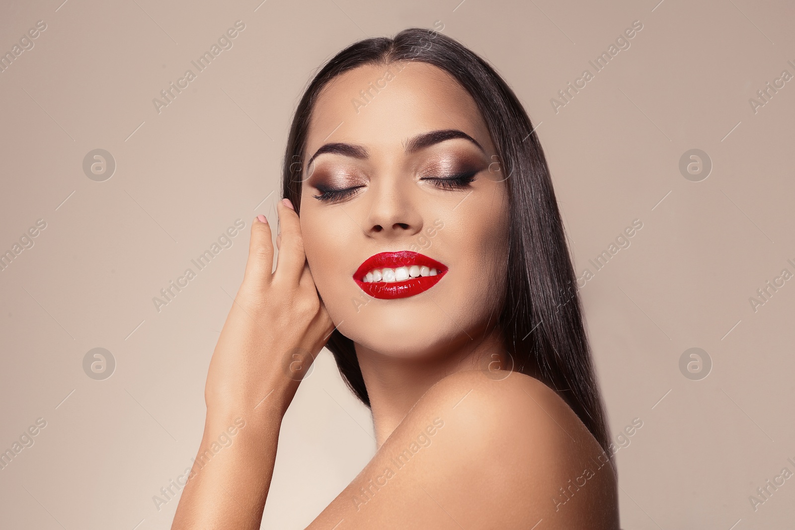 Photo of Portrait of beautiful young woman with red glossy lips on color background