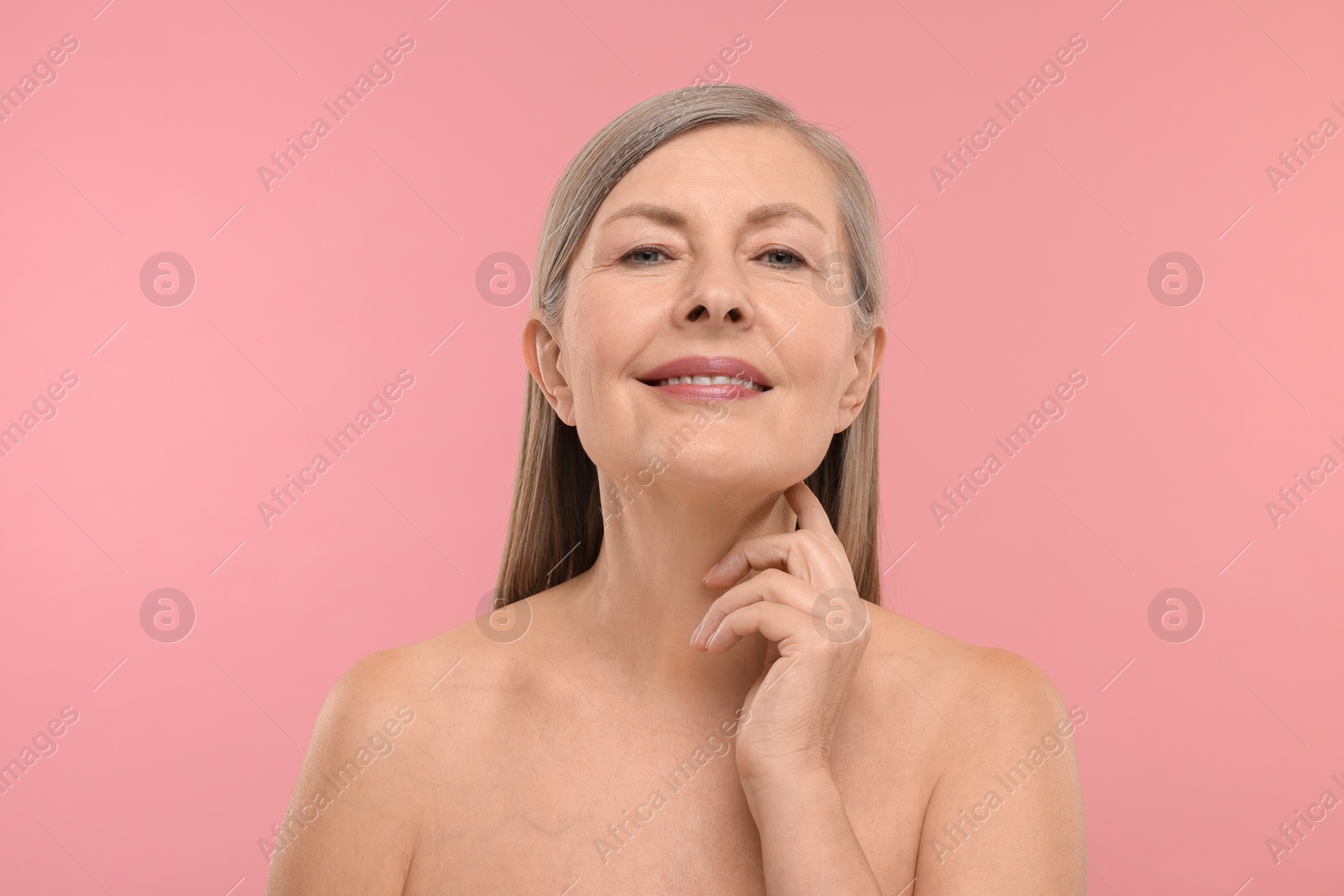 Photo of Beautiful woman touching her neck on pink background