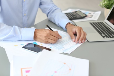 Photo of Tax accountant working with documents at table