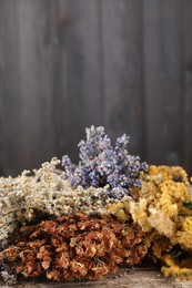 Many different dry herbs on wooden table, closeup. Space for text