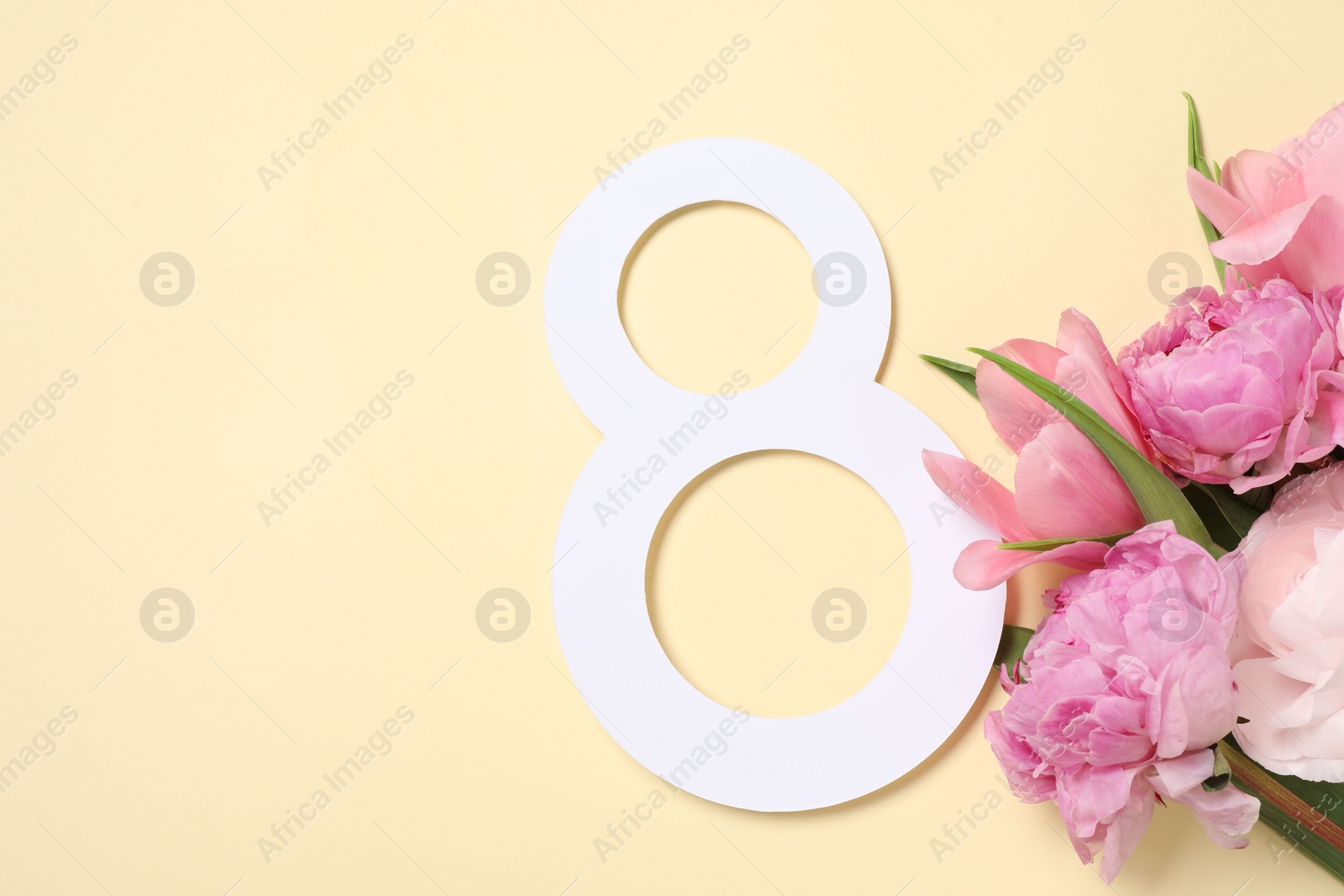 Photo of 8 March greeting card design with beautiful flowers on light yellow background, top view. Space for text