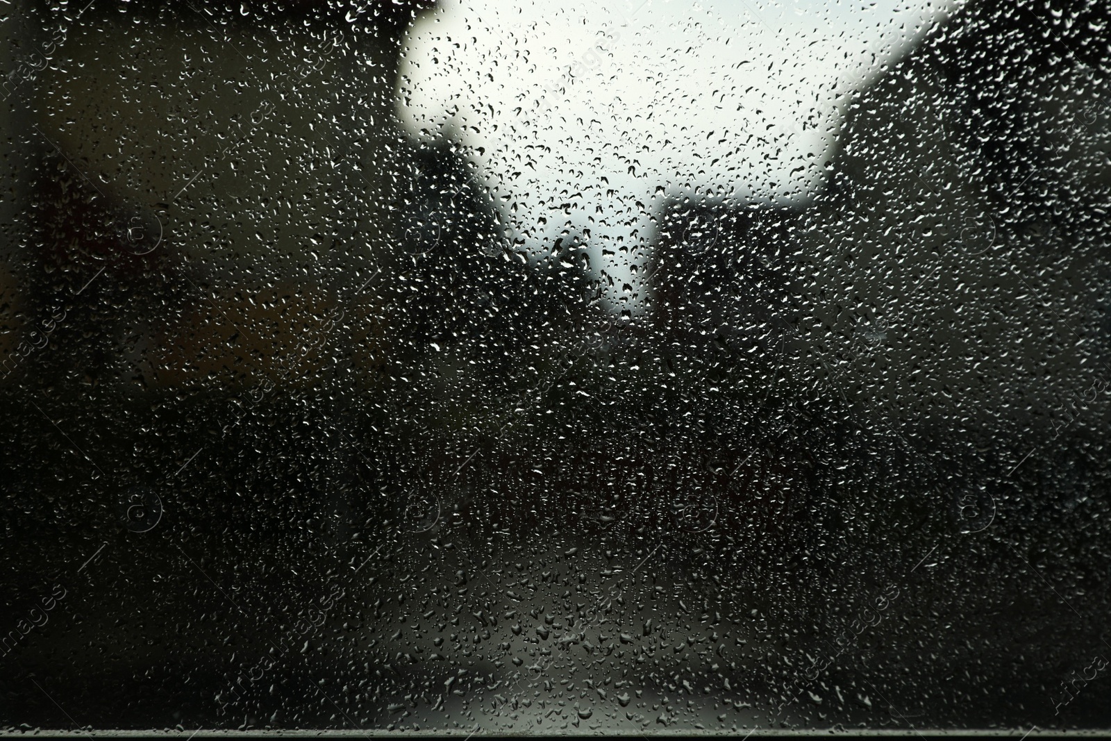 Photo of Blurred view of city street from window on rainy day