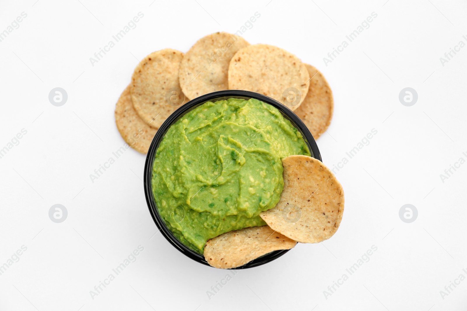 Photo of Delicious guacamole made of avocados and nachos on white background, top view