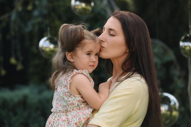 Portrait of mother with her cute daughter in park