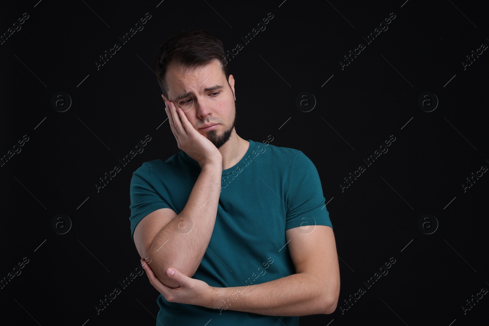 Photo of Portrait of sad man on black background