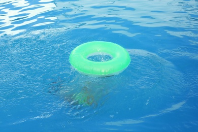 Photo of Little child with inflatable ring in outdoor swimming pool. Dangerous situation